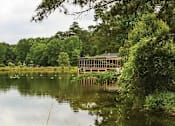 Thumbnail 2 of 12 - a house on the shore of a lake